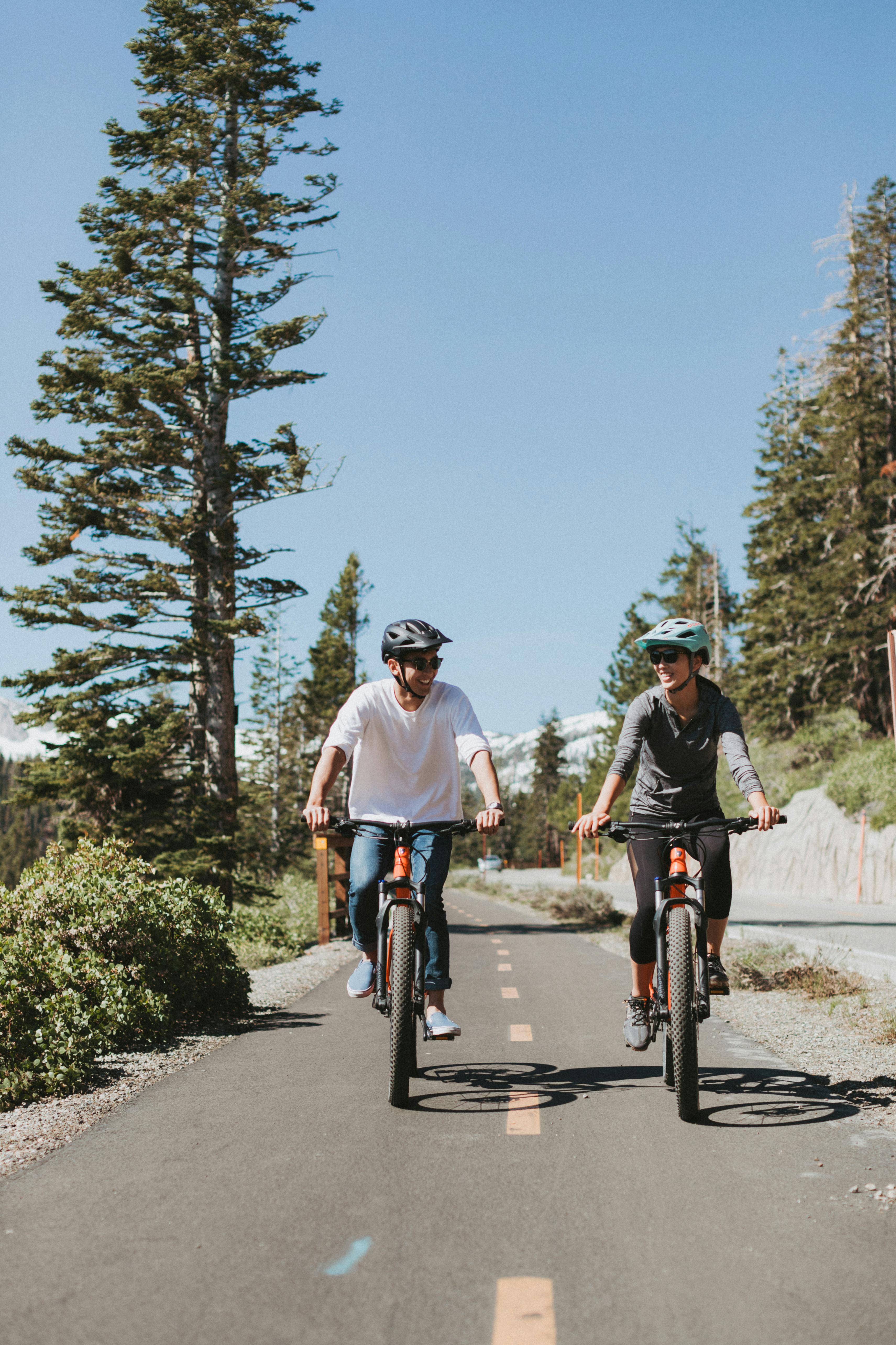 Couple riding bikes on a town path.