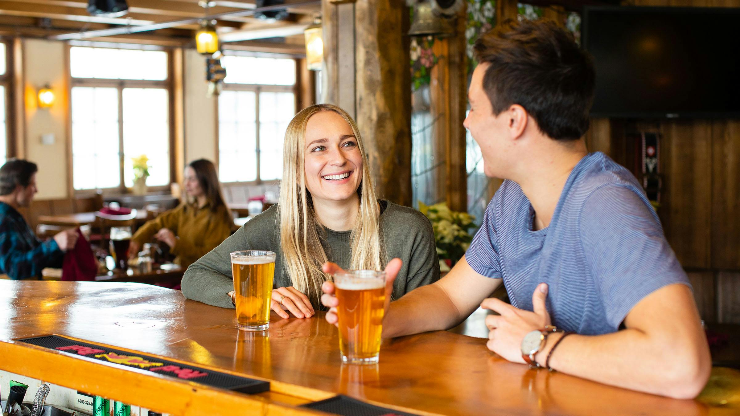 Woman and man drinking beer at Yodler Restaurant and Bar