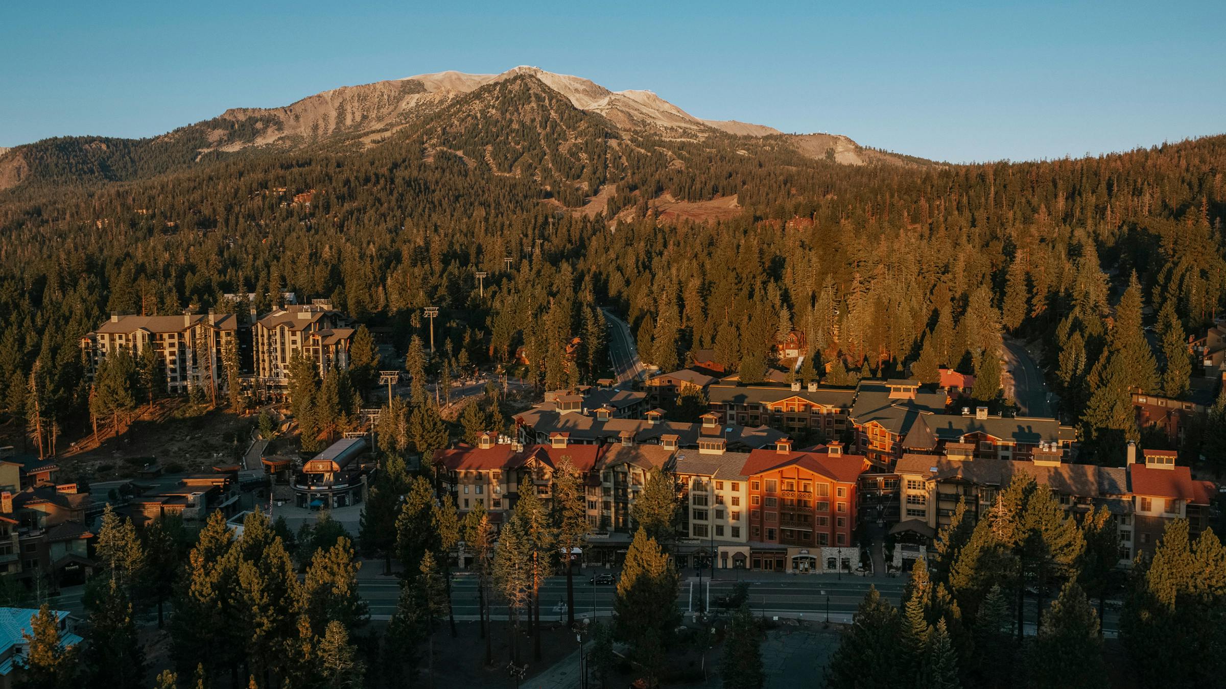 Drone shot of The Village at Mammoth during summer with Mammoth Mountain in the background