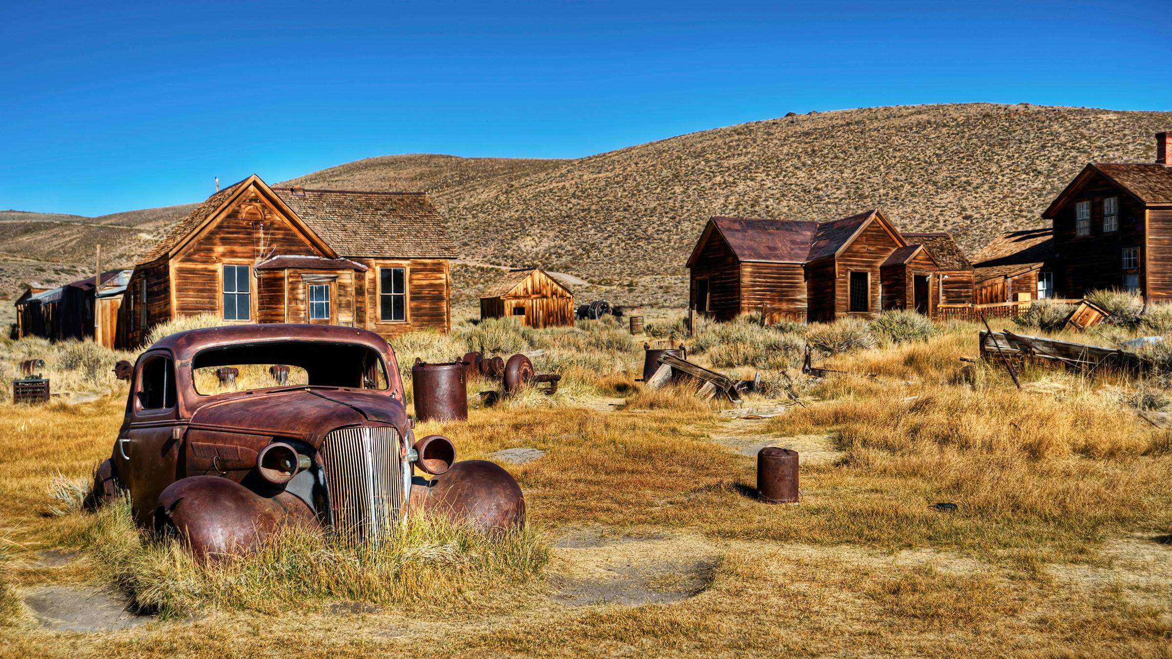 Bodie State Historic Park ghost town with abandoned car and buildings