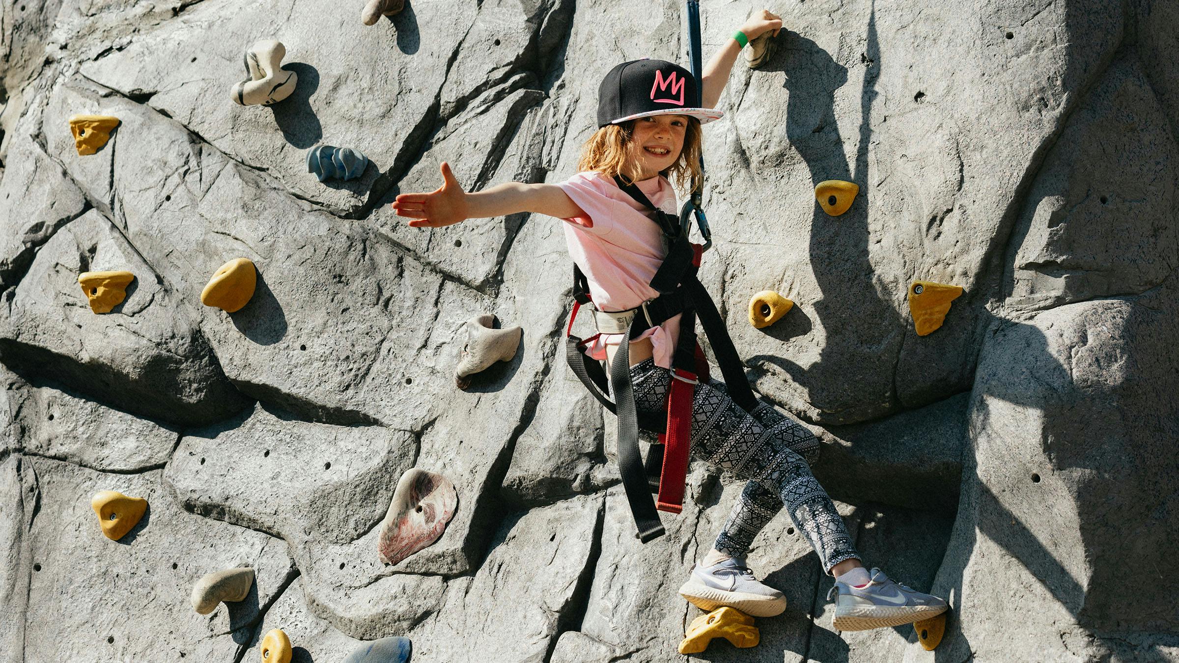 Girl climbing on climbing wall at the Adventure Center at Mammoth Mountain
