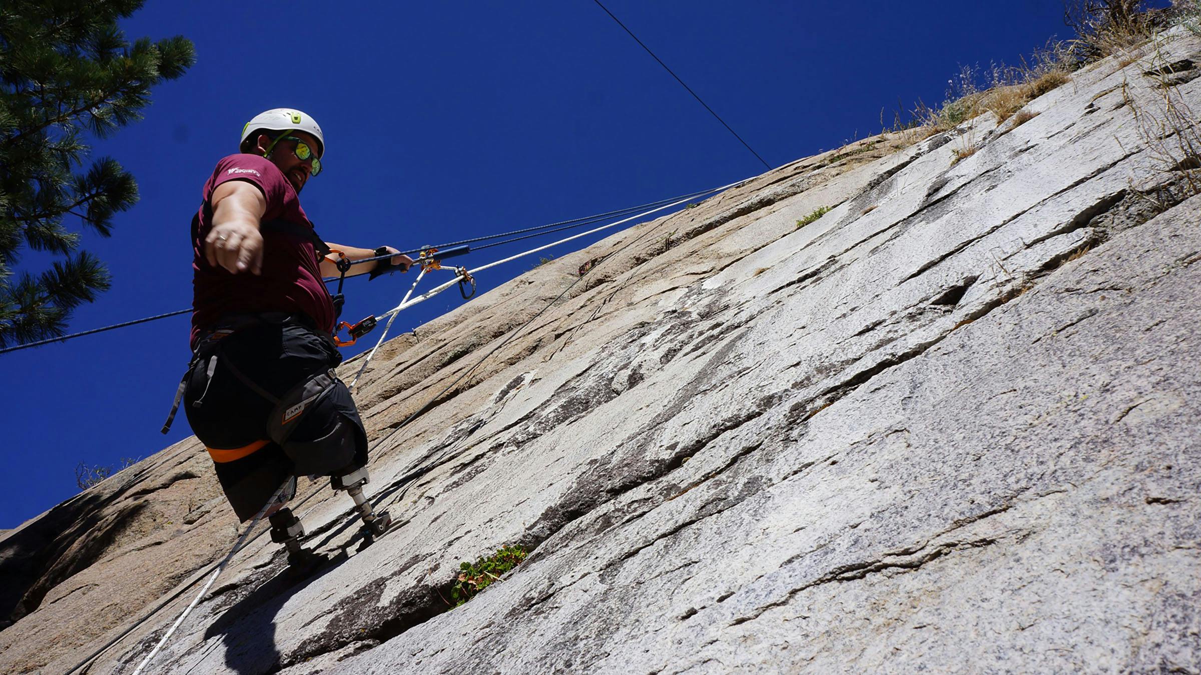 Adaptive climber rappeling on rock