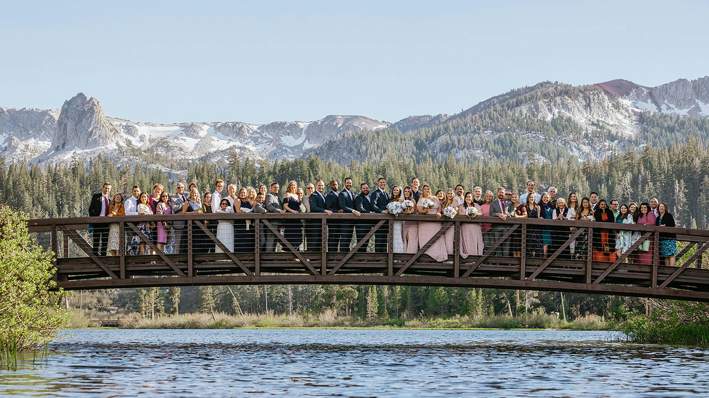 Wedding party posing for photo on bridge over Twin Lakes