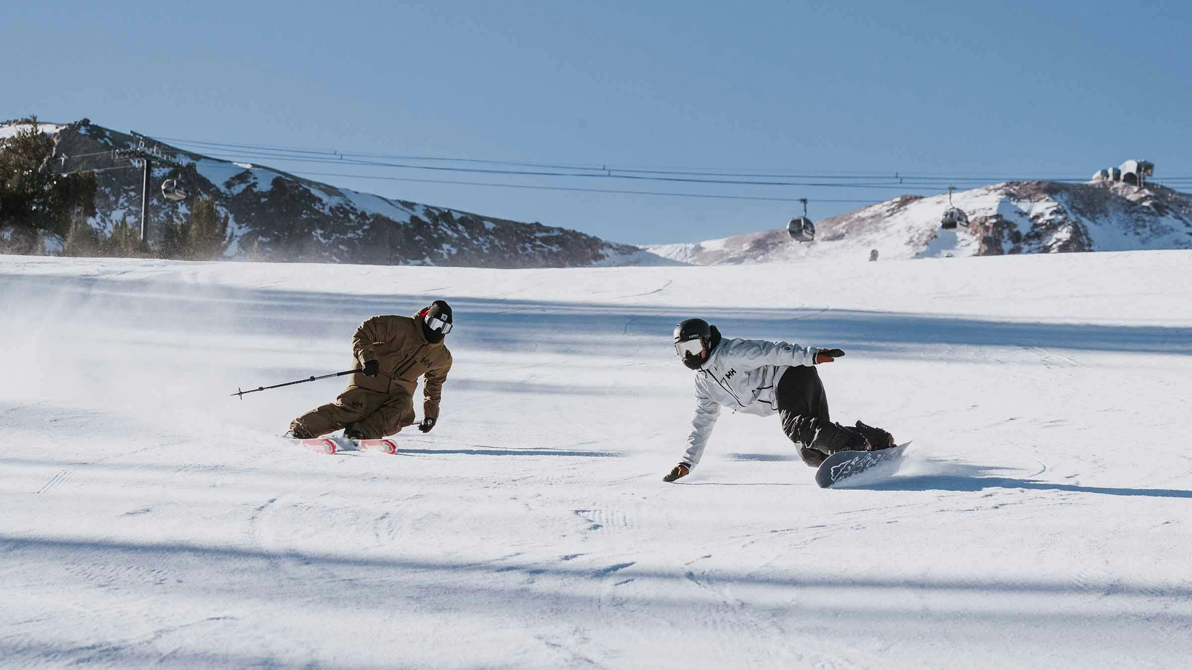 Skier and snowboarder riding groomers