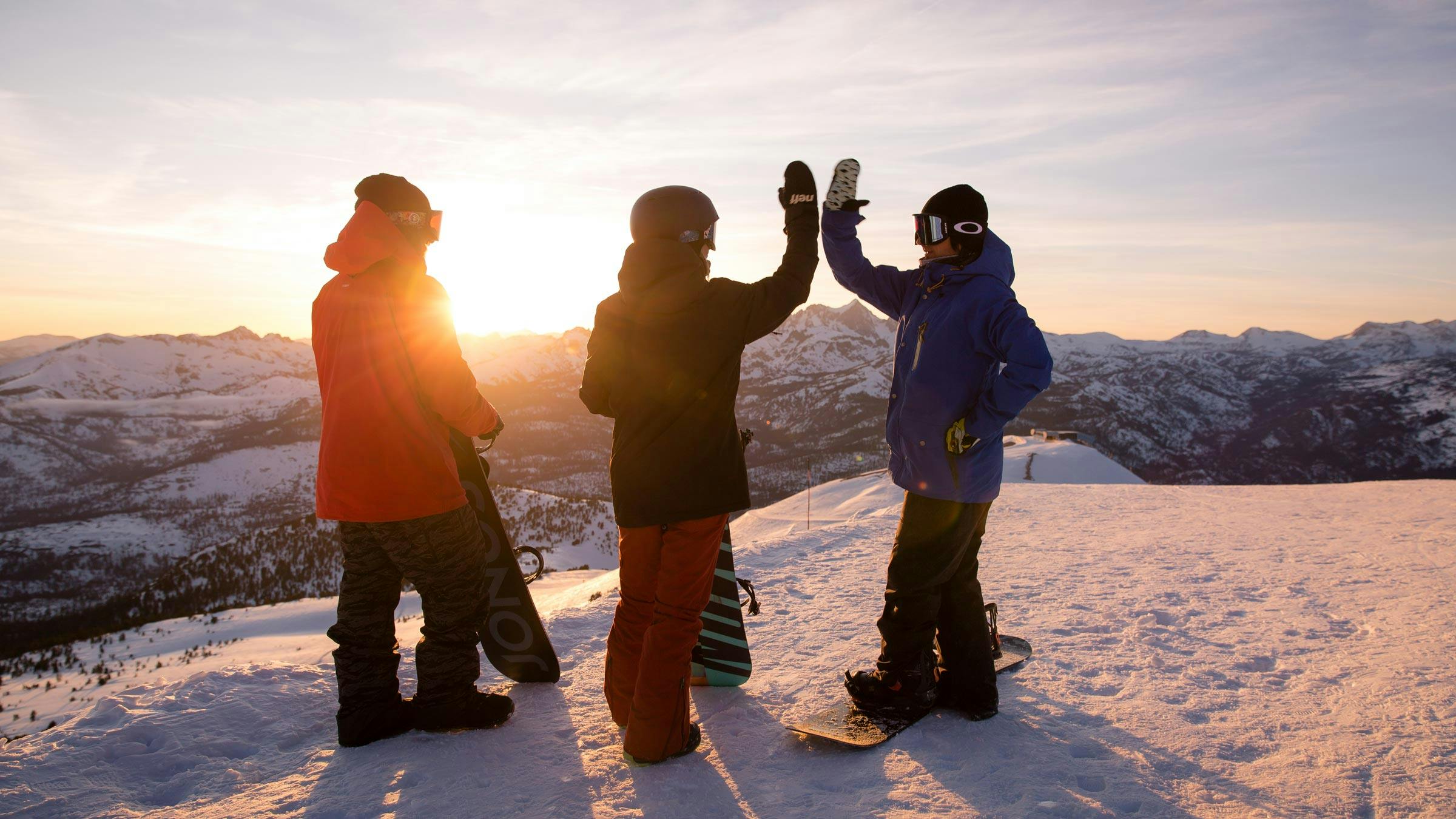 Friends on snow at sunset
