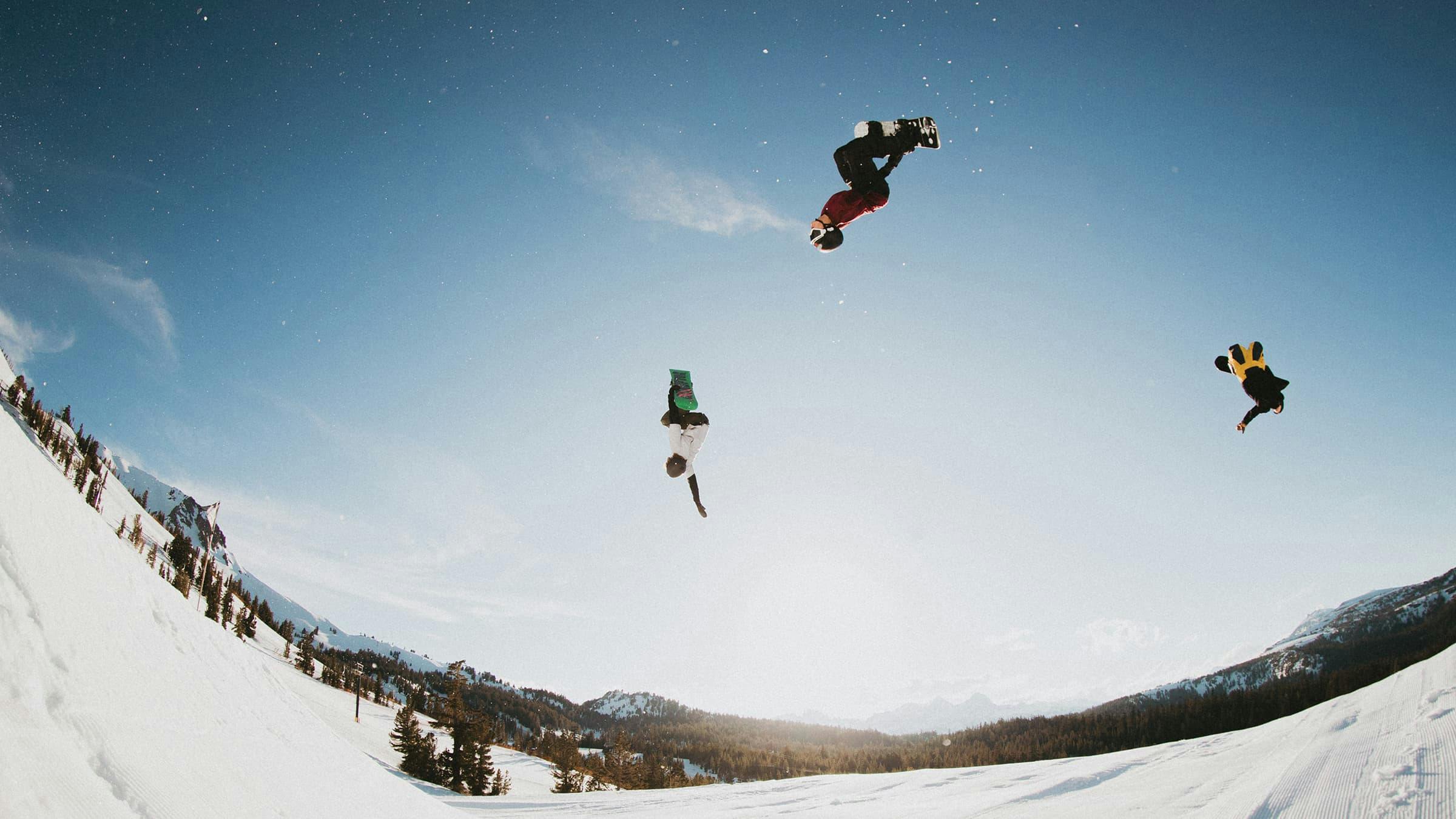 Three snowboarders catching air at Unbound Terrain Park