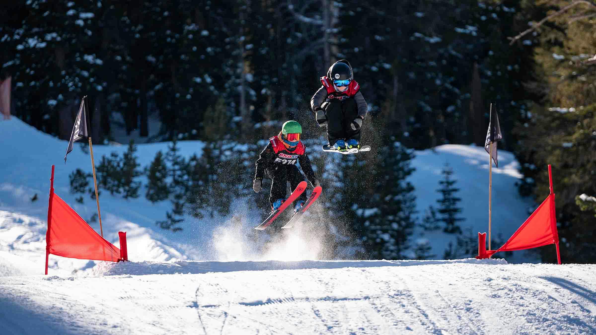 Two kids competing in a ski cross competition